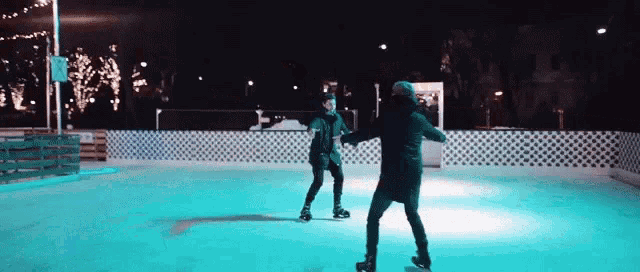 a couple of people are ice skating on a rink