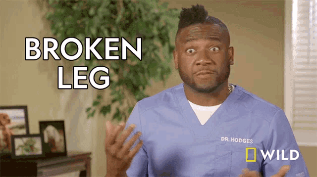 a man in a blue scrub has the words broken leg on his shirt