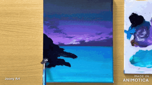 a painting of a sunset by joony art is on a table