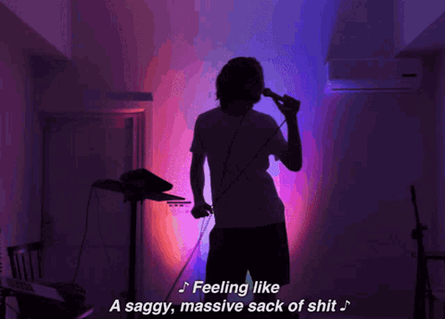 a person singing into a microphone with the words feeling like a saggy massive sack of shit