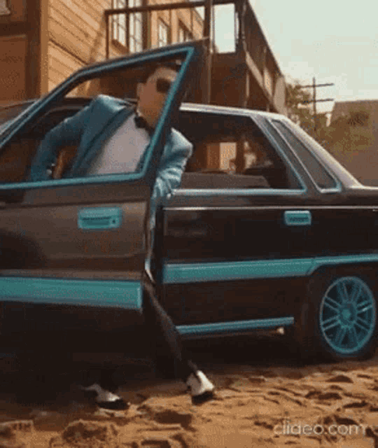a man in a suit is getting out of a black car