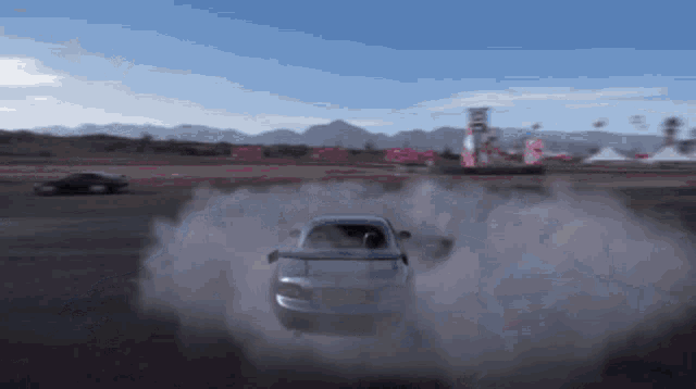 a car is drifting on a track with smoke coming out of the tires