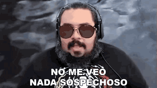 a man with a beard wearing sunglasses and headphones says " no me veo nada sospechoso "