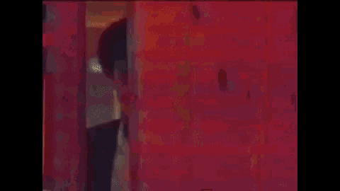 a close up of a man 's face in a dark room with red lights .