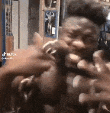 a man is making a funny face while being slapped by another man .