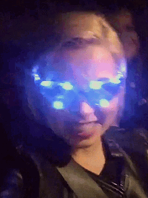 a person wearing glow in the dark glasses with a purple background