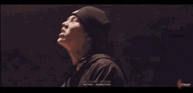 a man is dancing in a dark room with smoke coming out of the walls .