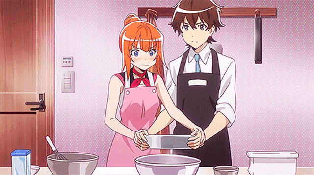 a man and a woman are standing next to each other in a kitchen cooking .