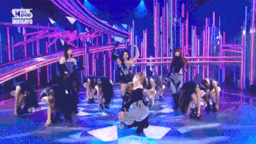 a group of women are dancing on a stage with a sign that says kpop on it .