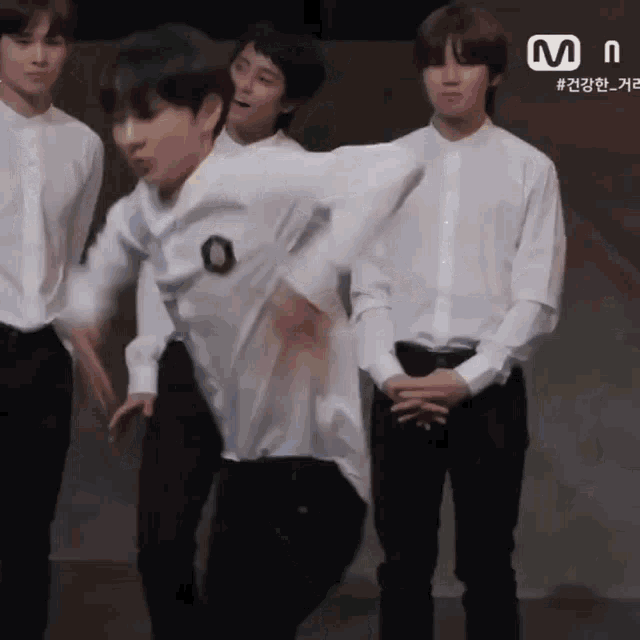 a group of young men in white shirts are standing in front of a sign that says mnet