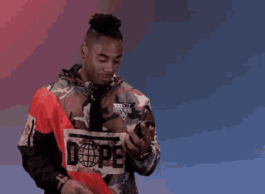 a man wearing a camouflage jacket with the word dope on the front