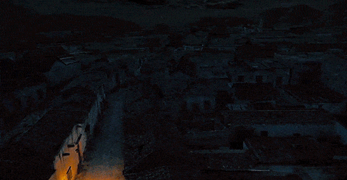 an aerial view of a city at night with a few lights on