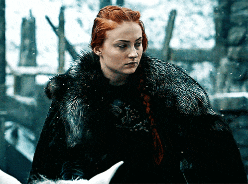 a woman with red hair wearing a black fur coat