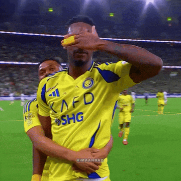a soccer player wearing a yellow kafd shg jersey covers his eyes