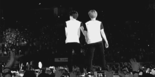 two men are standing on a stage in front of a crowd .