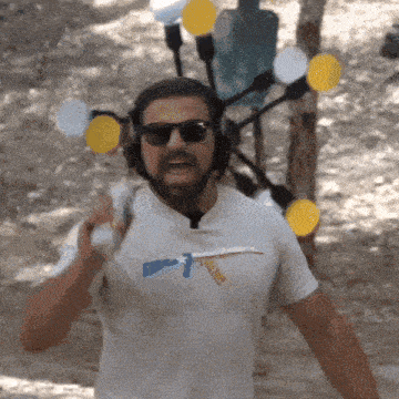 a man wearing headphones and sunglasses is holding a gun in his hand