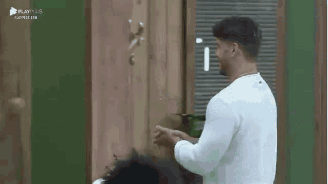 a man and a woman are standing next to each other in front of a door and laughing .