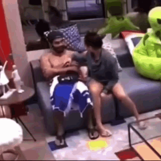 a man and a woman are sitting on a couch in a room .