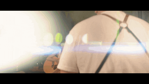 a man playing a guitar with the letter g on it