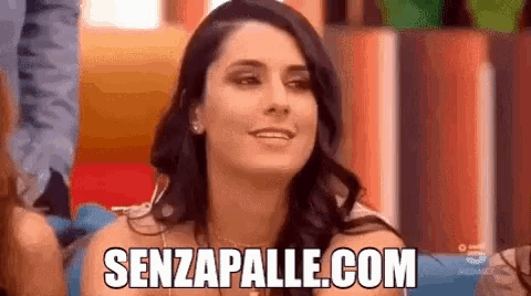 a woman is smiling and says senzapalle.com in front of a crowd .