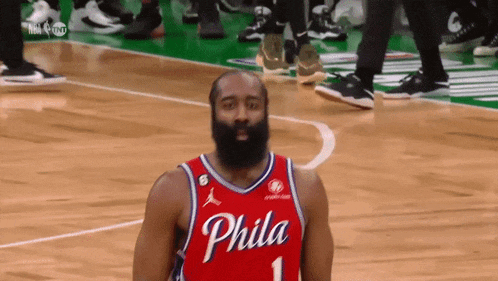 a philadelphia basketball player with a beard wearing a red jersey
