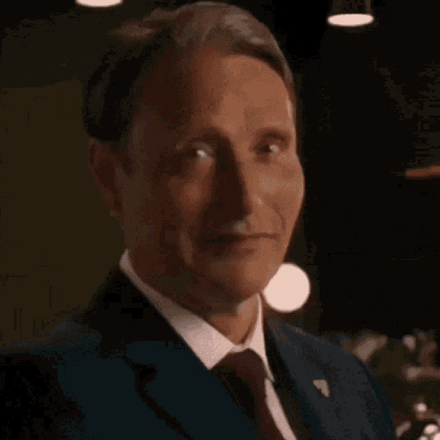 a man in a suit is holding a glass of beer .