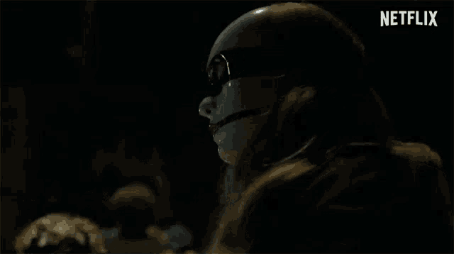 a woman wearing a mask and sunglasses in a dark room .