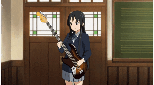 a girl is holding a guitar in front of a blackboard
