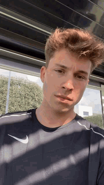 a young man wearing a black nike shirt