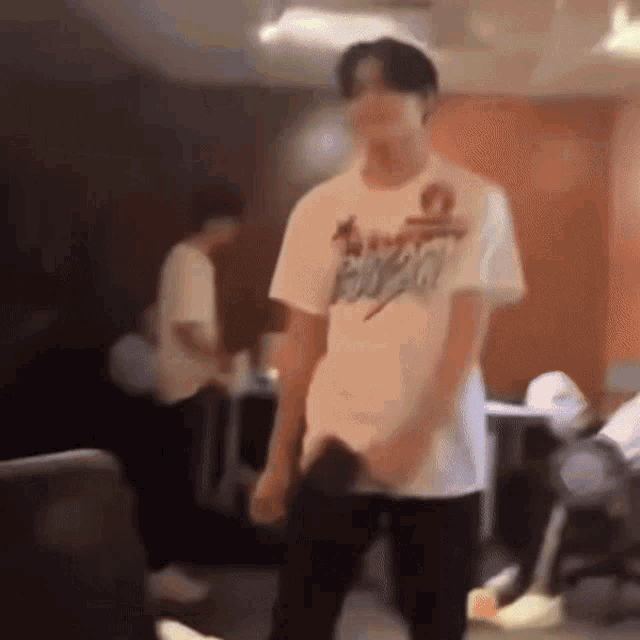 a blurry picture of a man wearing a white t-shirt that says buzz