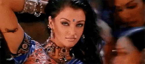 a woman in a blue dress is dancing in front of a crowd .