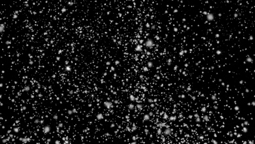 snow is falling on a black background in slow motion .