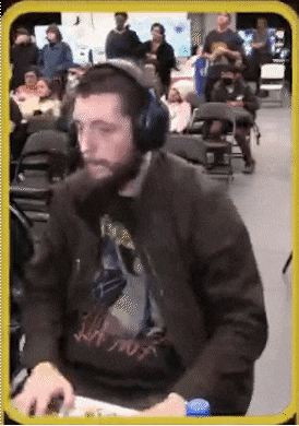 a man with a beard wearing headphones is sitting at a table with a computer mouse .