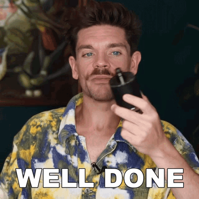 a man in a tie dye shirt is holding a bottle and the words well done are on the bottom