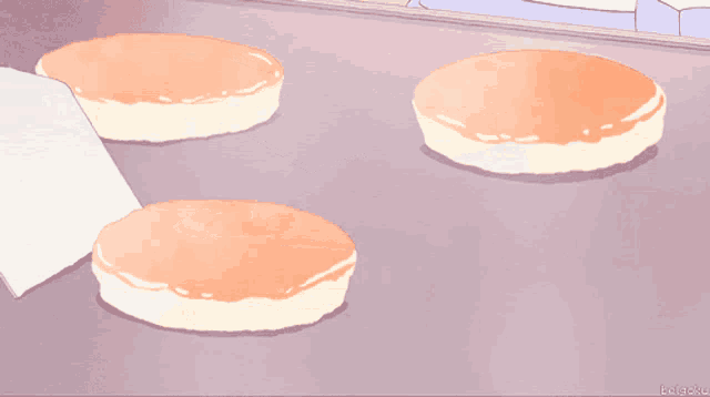 three pancakes are sitting on a tray with a purple background and the letters rkgoku on the bottom