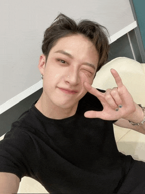 a young man wearing a black shirt is making a peace sign