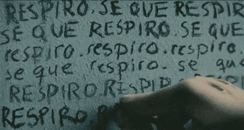 a person is writing on a wall that says " respiro se que respiro "