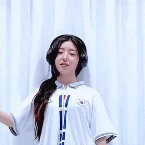 a girl wearing headphones and a shirt with a korean flag on it