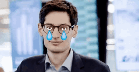 a man wearing glasses and a suit has tears coming out of his eyes