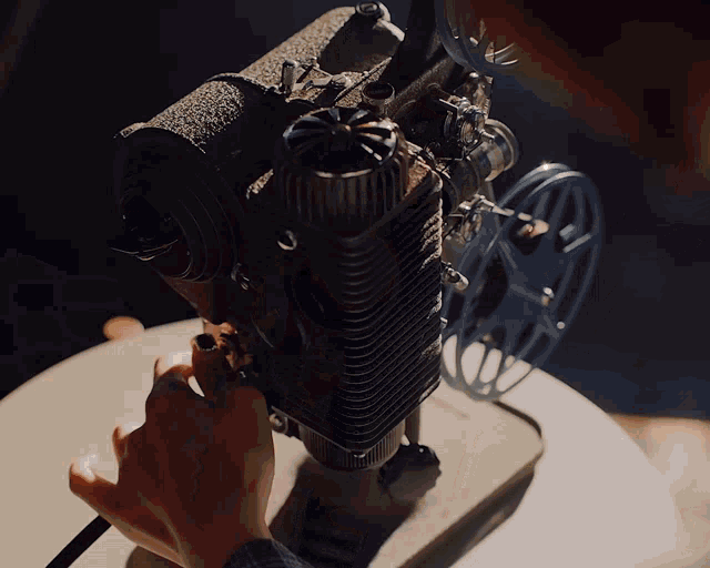 a close up of a person 's hand holding a projector