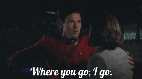 a man in a red uniform is hugging a woman with the words where you go i go