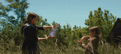 a woman holds a purple object in her hand while another woman looks on
