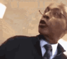a man in a suit and tie is looking up at something .