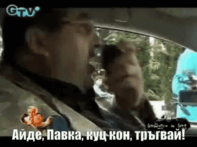 a man in a car with a gtv logo on the bottom of the screen