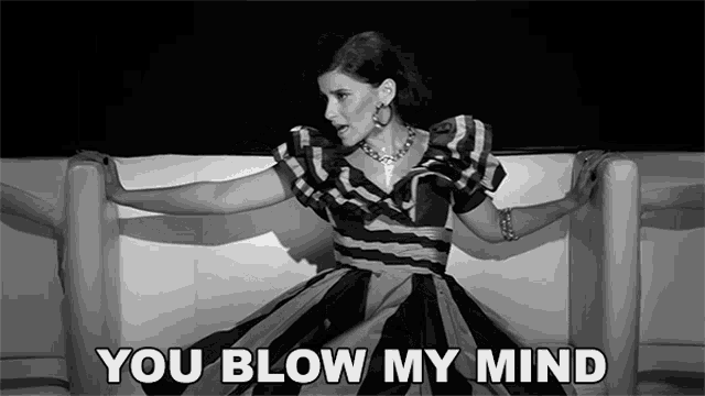 a woman in a striped dress is sitting on a white couch with the words " you blow my mind " written below her