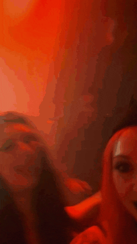 a blurry picture of a person 's face in front of a red background