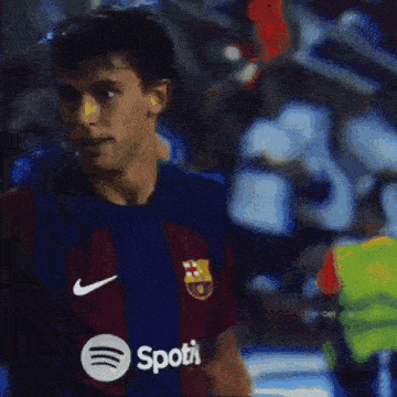 a soccer player is wearing a shirt that says ' spotify ' on it