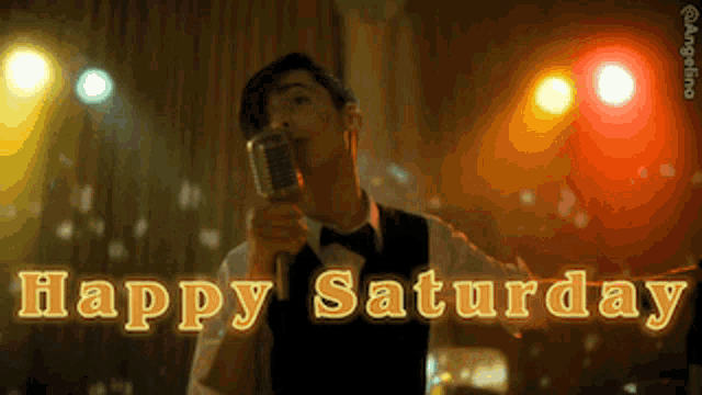 a man is singing into a microphone with the words happy saturday behind him