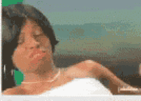 a woman is laying in a bathtub with her eyes closed and a towel around her shoulder .