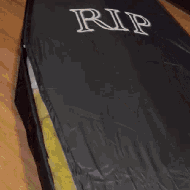 a black coffin with rip written on the side of it